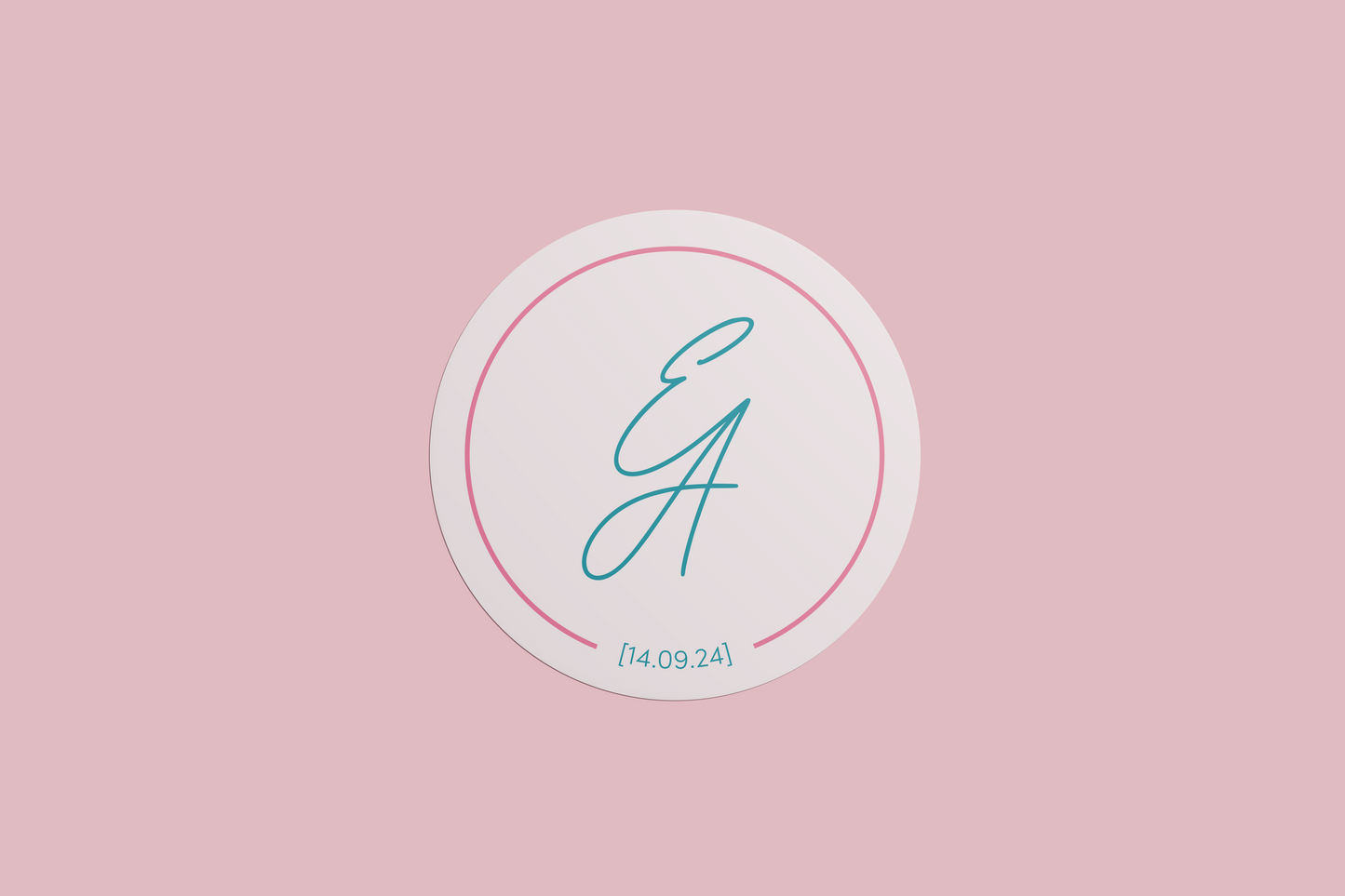 A circular wedding sticker design with the initials "E & A" in a teal script font, surrounded by a thin pink border, and the date "14.09.24" beneath, all set on a soft blush pink background.