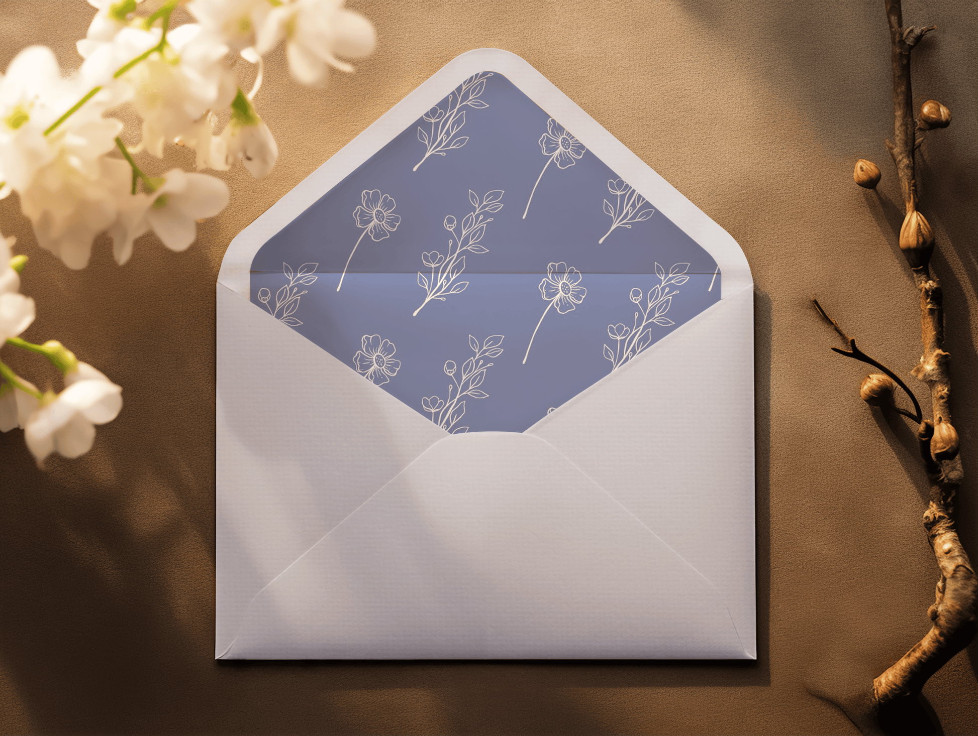 A close-up of a white envelope with a floral liner in a soft lavender tone, featuring delicate white line drawings of flowers and leaves.