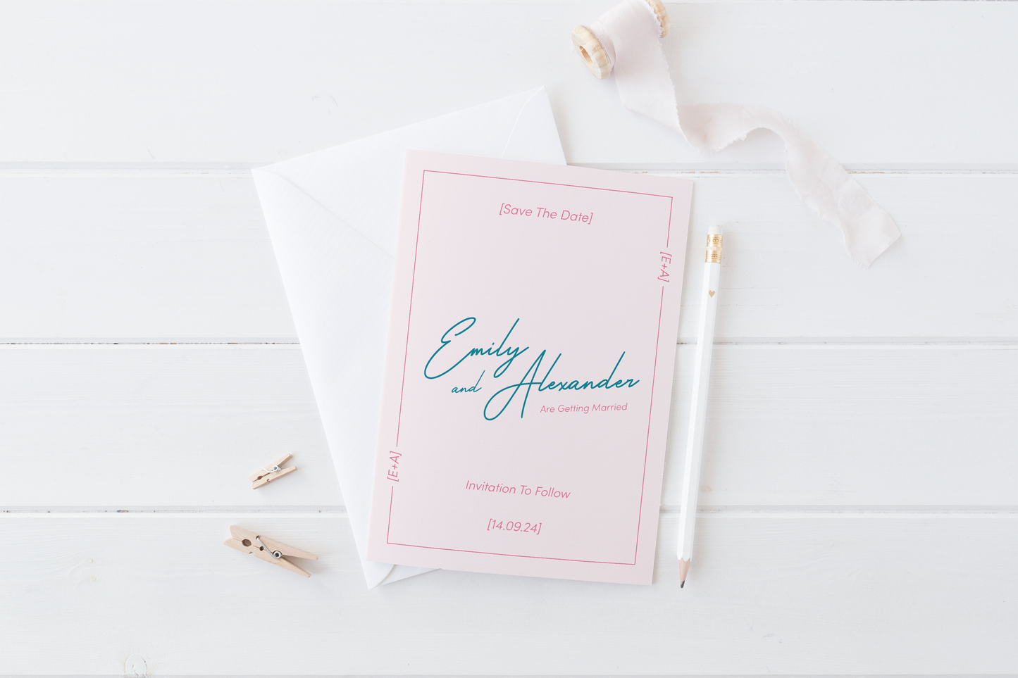 
A modern and minimalistic "Save the Date" card for Emily and Alexander's wedding is displayed on a white wooden surface. The card has a soft blush pink background with teal and fuchsia typography. The names "Emily and Alexander" are elegantly written in the center, accompanied by the wedding date "14.09.24" at the bottom. A thin decorative border surrounds the card, with "E+A" displayed in the corners.