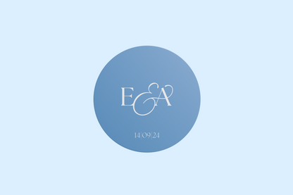 A circular wedding sticker featuring the initials "E & A" in an elegant white serif font and the date "14 | 09 | 24" beneath, all set against a soft blue gradient background.